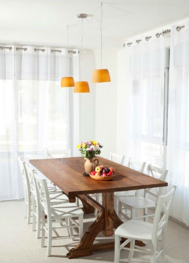 Drewniany stół i białe krzesła, fot.: Liliach Shahaf