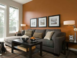 Na tle pamarańczowej ściany ustawiono sofę, źródło: designico.jpg